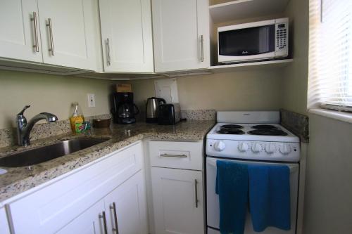 a small kitchen with a stove and a microwave at Sunny Isles Apartments by MiaRentals in Sunny Isles Beach