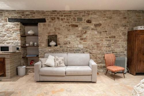 a living room with a couch and a brick wall at Mamihouse in Gubbio