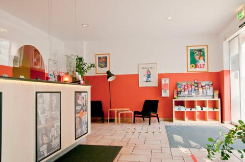a store with red walls and a table and chairs at Happy Hotel Berlin in Berlin