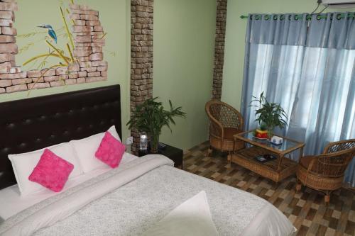 1 dormitorio con 1 cama con almohadas rosas en Hotel Happy Home, en Chitwan