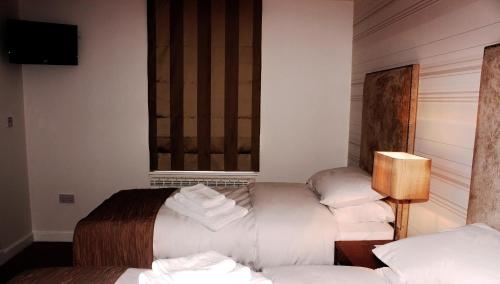 a hotel room with two beds and a window at McCafferty's Guesthouse Ilford in Ilford