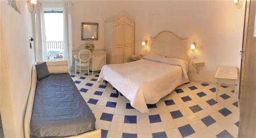 1 dormitorio con 1 cama y suelo azul y blanco en Pensione Maria Luisa, en Positano