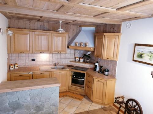 cocina con armarios de madera y encimera en Taverna Larice en Valdidentro