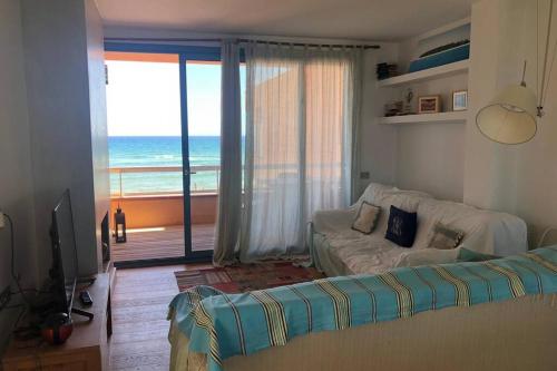 sala de estar con sofá y vistas al océano en Paraíso Playa de Pals - reformado primera línea de mar con parking en Pals