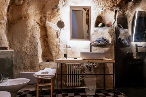 ein Badezimmer mit einem Waschbecken, einem WC und einem Spiegel in der Unterkunft 19.52 Matera in Matera