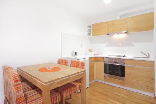 a kitchen with a wooden table with chairs and a sink at Vila Bjanka in Zlatibor