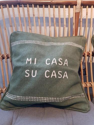 a green pillow with the words mucas sur casa sul casa at Beachhouse Langeland 20 m to private Beach in Tranekær