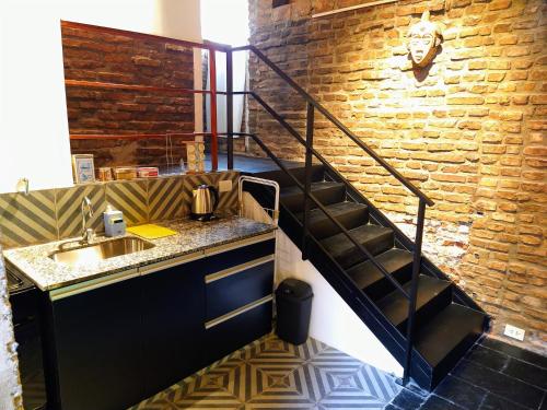 a kitchen with a sink and a brick wall at Casa Palacio, Arte e Historia in Buenos Aires