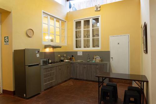 a kitchen with a refrigerator and a table in it at Wild Olive Guest House in Ica