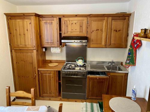 a kitchen with wooden cabinets and a stove top oven at Casa Ornella in Courmayeur