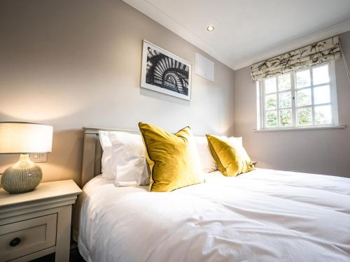 a bedroom with a large white bed with yellow pillows at Farmcourt Barn 57 Eastfield Lane in Lincoln