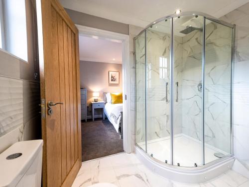 a bathroom with a walk in shower next to a tub at Farmcourt Barn 57 Eastfield Lane in Lincoln