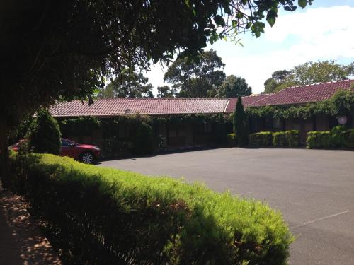 a car parked in a parking lot next to a building at Nunawading Motor Inn in Nunawading