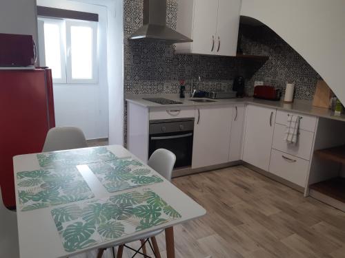 a kitchen with white cabinets and a table with chairs at Casa Quimeres in Denia