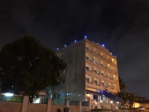 a building with lights on top of it at night at Maple Leaf Korean Hotel in Accra