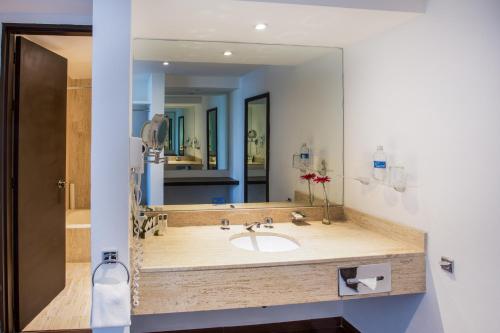 a bathroom with a sink and a large mirror at Hotel Real de Puebla in Puebla