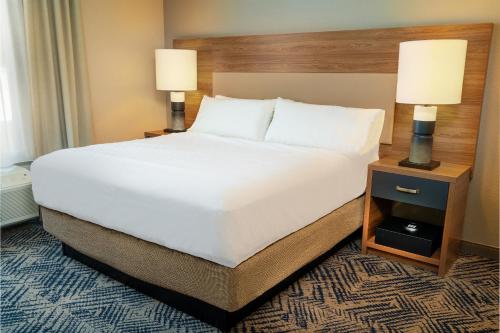 a large bed in a hotel room with two lamps at Candlewood Suites - Las Vegas - E Tropicana by IHG in Las Vegas