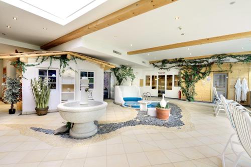 a living room with a fountain in the middle of a room at Hotel Vitalquelle Montafon in Schruns-Tschagguns