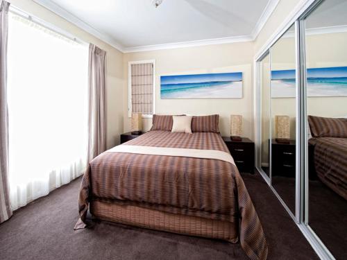 a hotel room with a bed and a couch at Dolphin Shores in Vincentia
