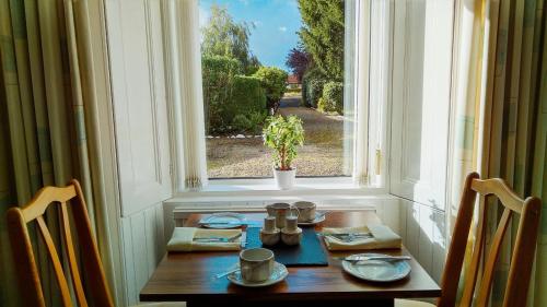 una mesa en una ventana con vistas a una calle en The Laurels Guest House en Blairgowrie