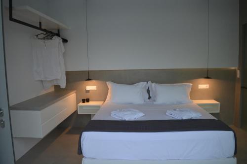 a bedroom with a bed with two towels on it at Thalasses Villas Skiathos in Skiathos Town