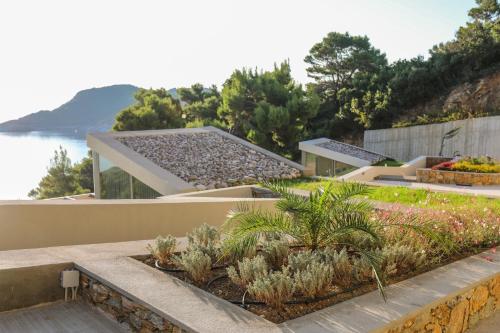 a house with a garden on the side of it at Thalasses Villas Skiathos in Skiathos Town