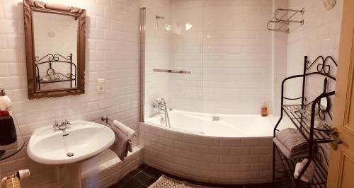 a white bathroom with a sink and a bath tub at Au 16 Place Saint Louis in Blois