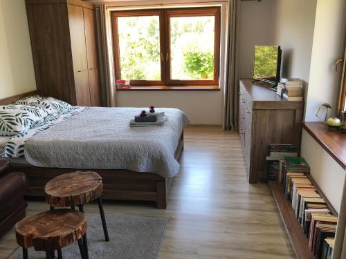 1 dormitorio con 1 cama y 2 taburetes en Czytelnia w Sadzie, en Krzykawka