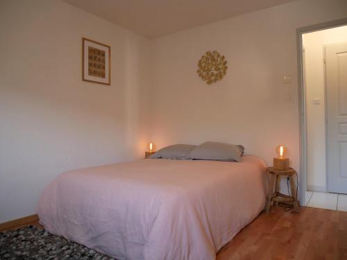 - une chambre dotée d'un lit blanc avec deux bougies dans l'établissement Appartement Les Papillons plein centre ville Gerardmer, à Gérardmer