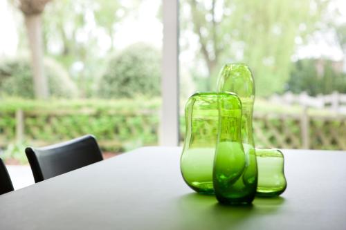 two green glass vases sitting on top of a table at Hotel Ter Elst in Edegem