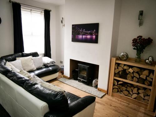 a living room with a couch and a fireplace at The Stone House in Nottingham