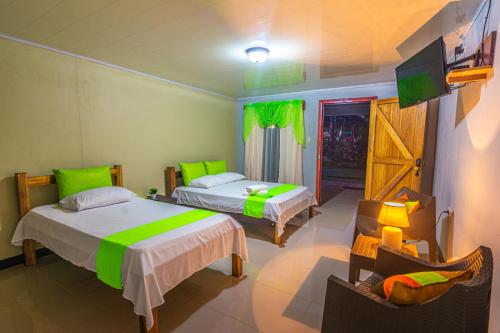 a hotel room with two beds and a tv at Rio Celeste Springs Blue Lodge in Bijagua