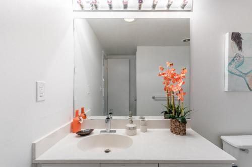 a white bathroom with a sink and a mirror at Sunny Isles Ocean Reserve Condo Apartments in Miami Beach
