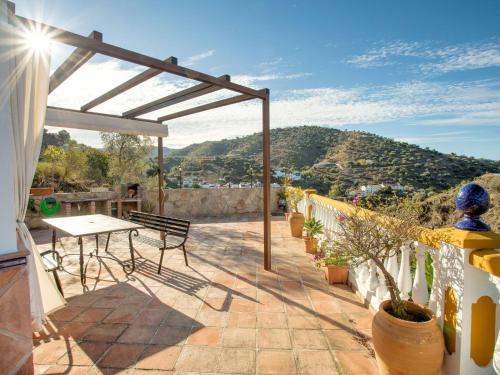 eine Terrasse mit einem Tisch und Stühlen auf dem Balkon in der Unterkunft Belvilla by OYO Casa Granadillos in Málaga