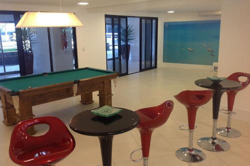 a room with a pool table and some red chairs at Landscape Beira Mar - Lindo, Luxo, Frente mar in Fortaleza