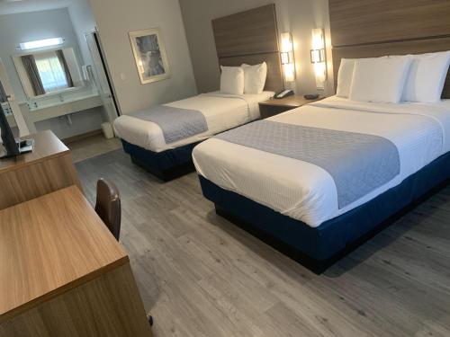 a hotel room with two beds and a desk at Porter Inn in Porter