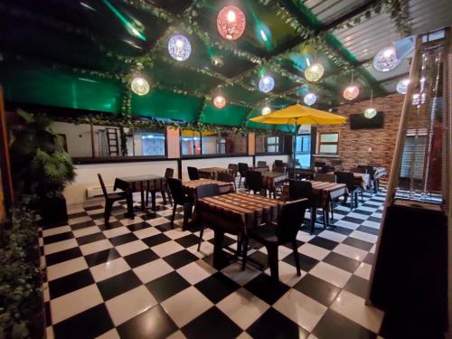 a restaurant with tables and chairs on a checkered floor at Hotel Espectacular in Callampaya