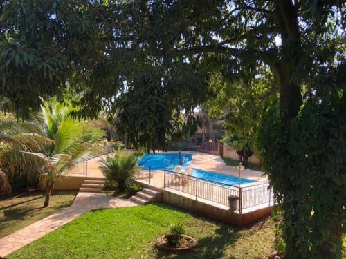 a backyard with a swimming pool and trees at Jardin Park Hotel in Jardinópolis