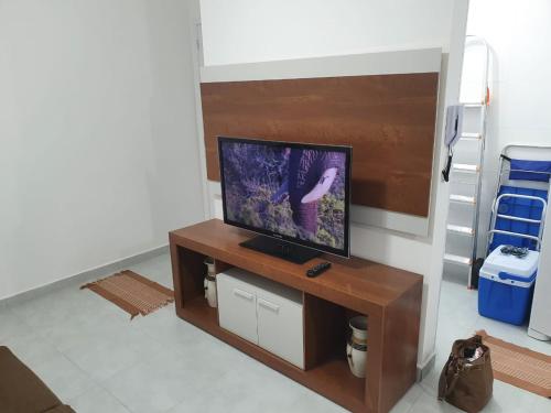 ein Wohnzimmer mit einem TV auf dem Tisch in der Unterkunft Lindo Apartamento em Ubatuba in Ubatuba