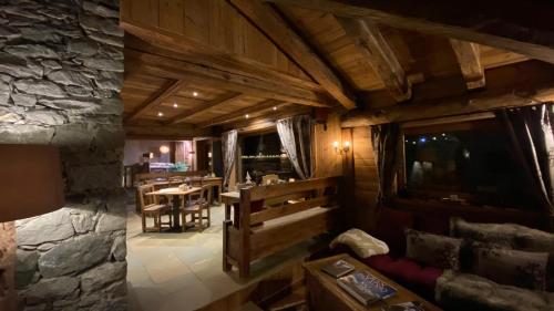 a living room with a table and a stone wall at Les Trompeurs chez Odette in Cogne