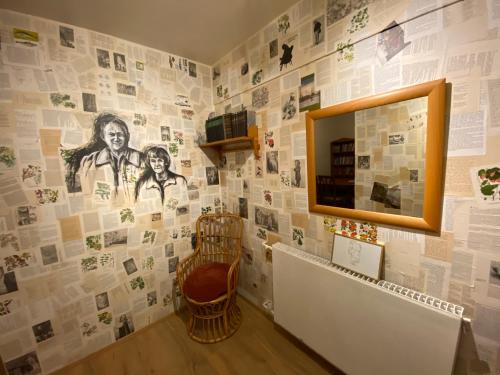 a room with a wall covered in photos and a mirror at The Bookstore Family Apartment in Hellissandur