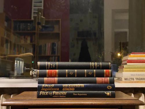 a stack of books sitting on a table at The Bookstore Family Apartment in Hellissandur