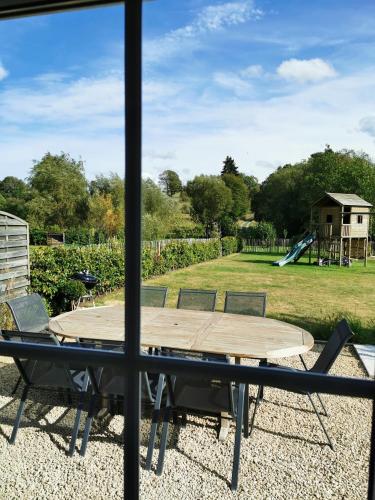 a view of a table and a playground from a window at A La Maison d'Ode in Sainte-Ode