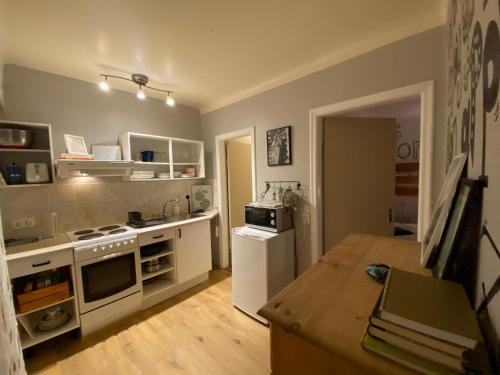 a kitchen with white appliances and a wooden table at The Bookstore Family Apartment in Hellissandur