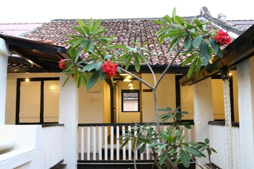 a house with red flowers on the front of it at Layang Layang Guest House Melaka in Melaka