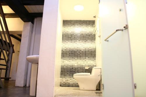 a bathroom with a toilet in a wall at Layang Layang Guest House Melaka in Melaka