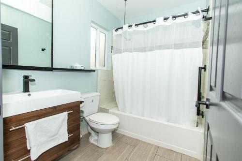 a bathroom with a toilet and a sink and a shower at Magnolia Tree Hotel-Maingate/Anaheim Convention Center in Anaheim