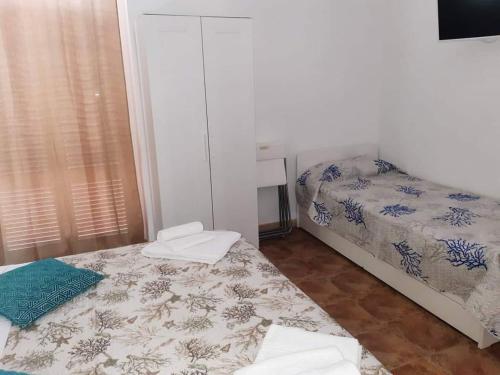 una piccola camera con due letti e una finestra di Le Suite dei Due Mari cucinino privato a Taranto
