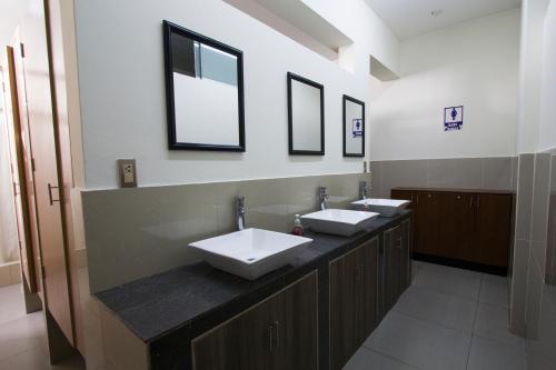 a bathroom with two sinks and two mirrors at Lima House Hostel in Lima