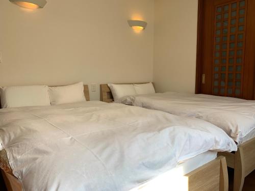 two beds sitting next to each other in a room at Luxury ocean front house Bay-villa in Matsushima